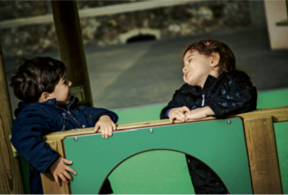 Deux enfants bavardent dans une structure collective de jeux