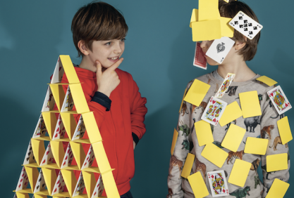 Deux enfants réalisent chacun un château de cartes. L’un a un montage parfait mais pas l’autre
