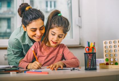 Une maman aide sa fille avec les devoirs pour préparer une évaluation