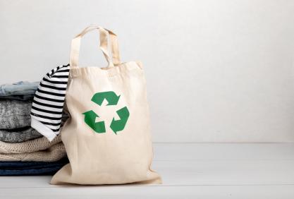 Pile de vêtements avec un tote-bag logo recyclage