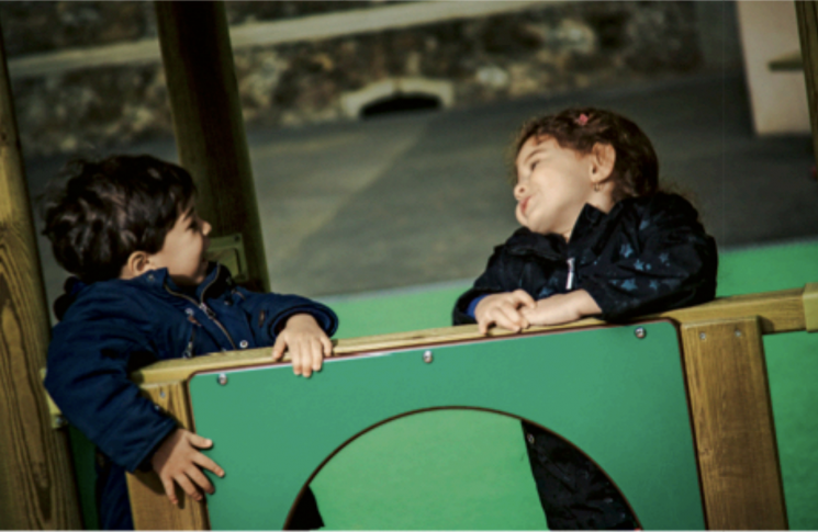 Deux enfants bavardent dans une structure collective de jeux