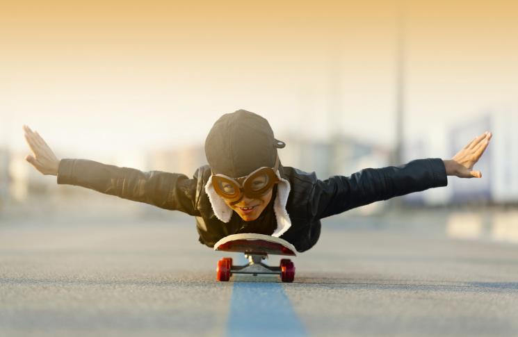 Un enfant sur un skate se prend pour un aviateur