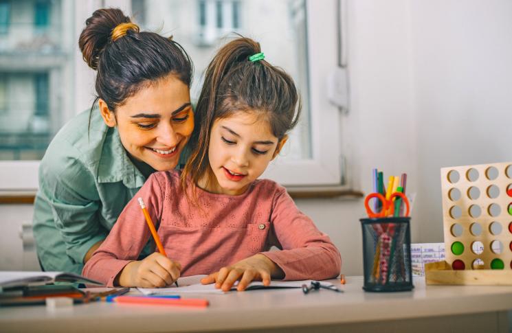 Une maman aide sa fille avec les devoirs pour préparer une évaluation