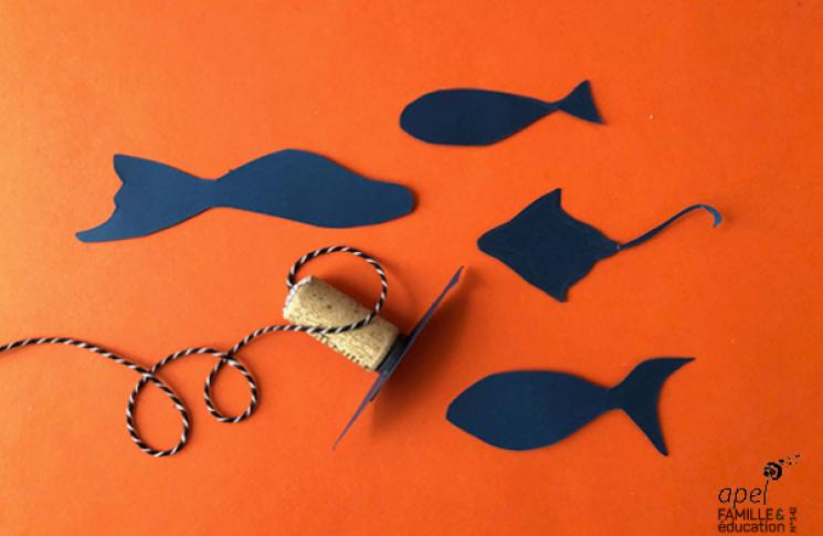 Des poissons en papier, du fil et un bouchon